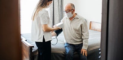 A physical therapists takes a patient's blood pressure.